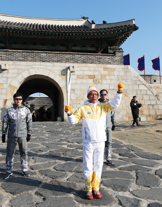 2018 평창동계올림픽 성화 봉송 주자가 5일 오후 경기도 수원시 세계문화유산 화성(華城) 창룡문 앞에서 파이팅을 외치고 있다.